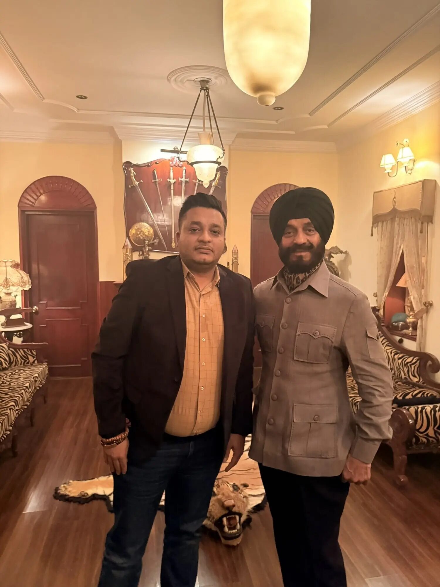 Nitish Jindal standing beside M. S. Bitta in a richly decorated room.