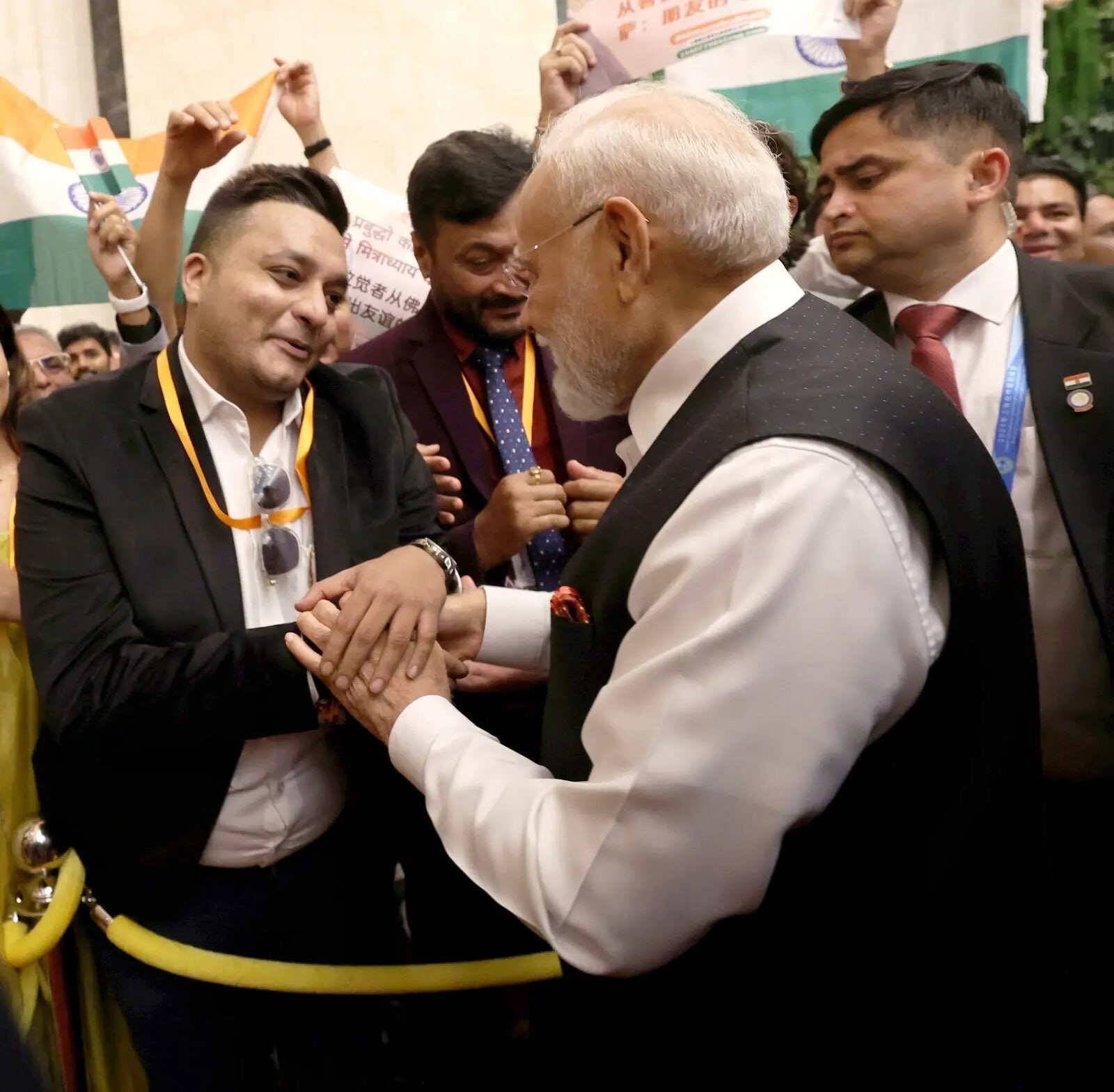 Nitish Jindal speaking with Narendra Modi as their hands meet during a public interaction.