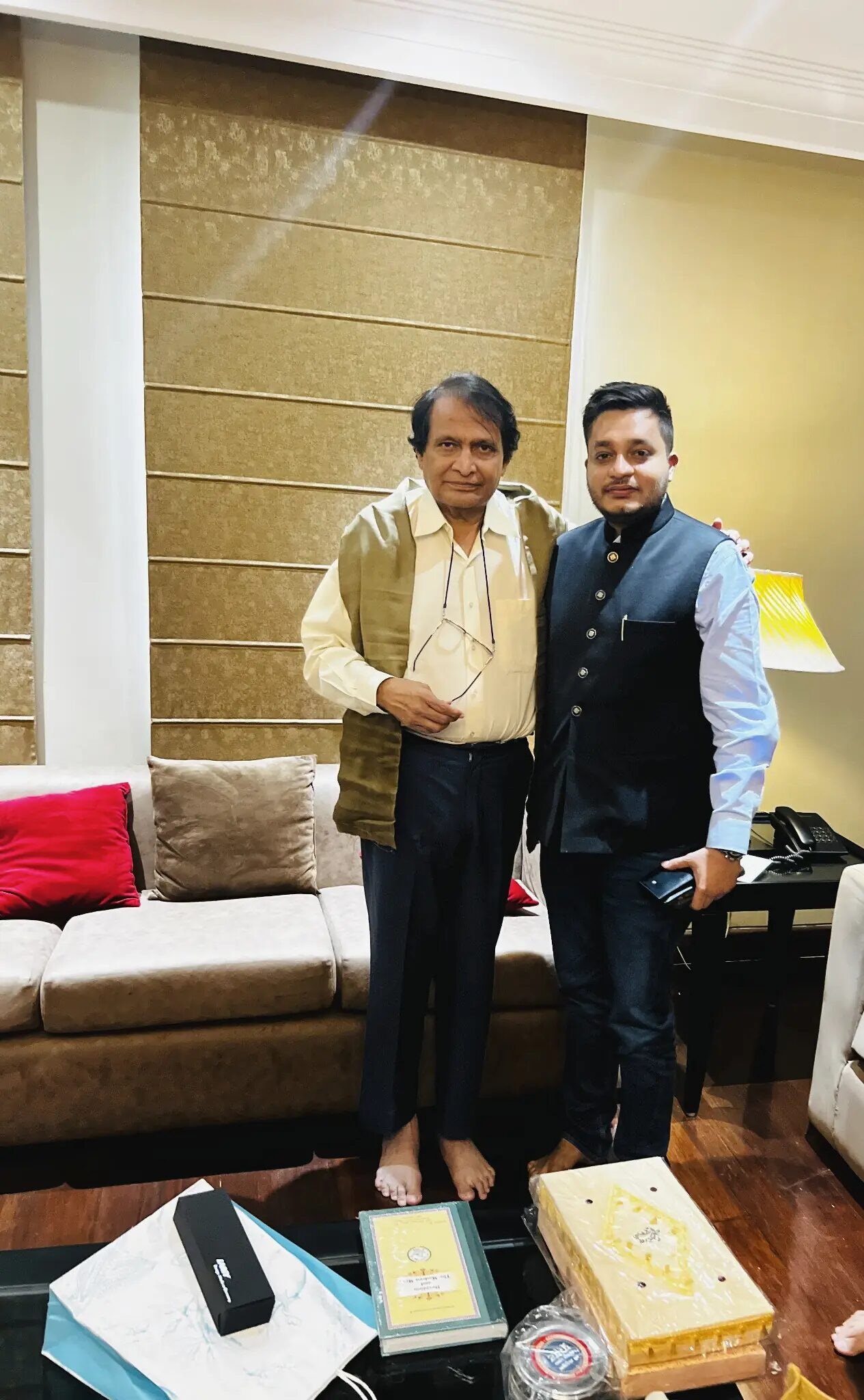 Nitish Jindal standing with Suresh Prabhu in front of a sofa and table.
