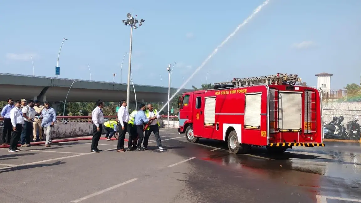 Personnel operate a fire hose beside a Goa State Fire Force vehicle during Operation Abhyaas in South Goa.
